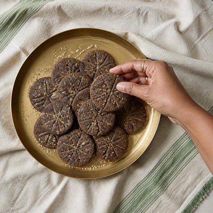 Ragi & Amaranth Jaggery Cookies by Early Foods on a brass plate