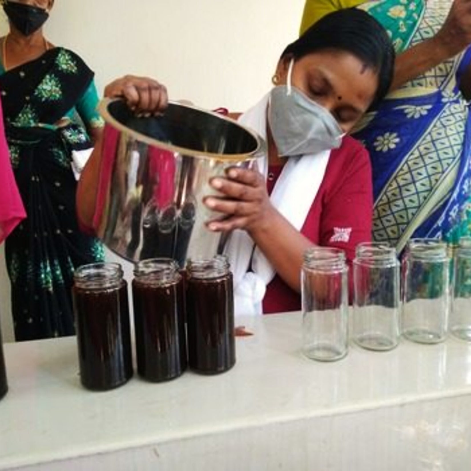 Filling and capping bottles by hand at the production unit