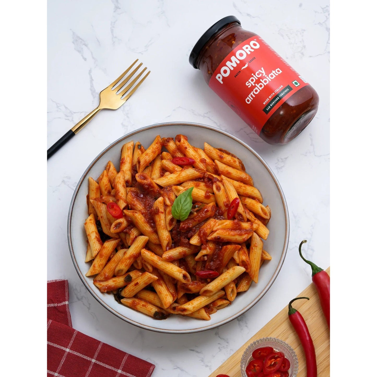 Bowl of penne in Spicy Arrabbiata sauce with the jar beside it