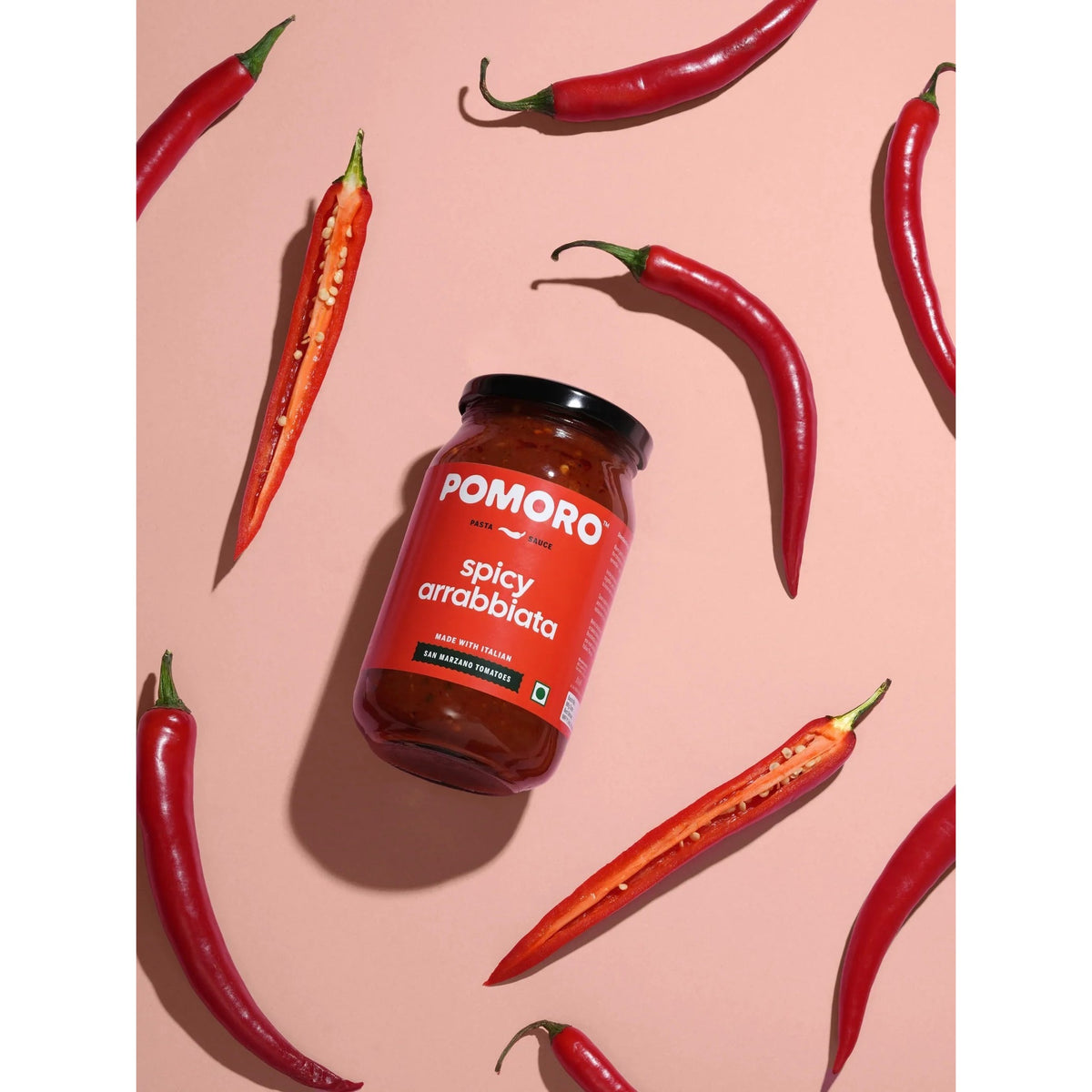 Pomoro Spicy Arrabbiata jar surrounded by whole and split red chillies