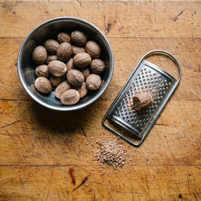 Nutmeg in a steel katori with a grater