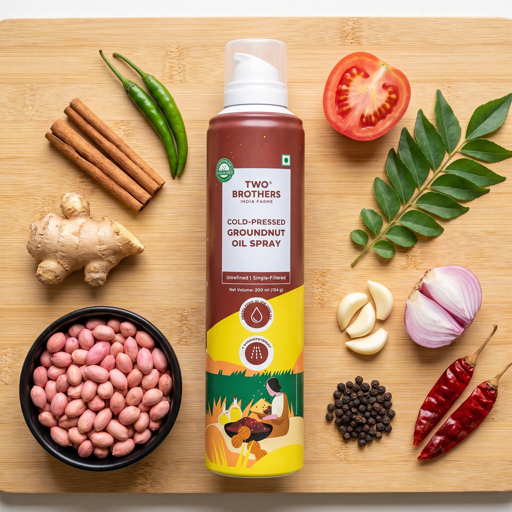 Groundnut oil spray can on a bamboo board with groundnuts, ginger, cinnamon, chillies, garlic, shallot and peppercorns