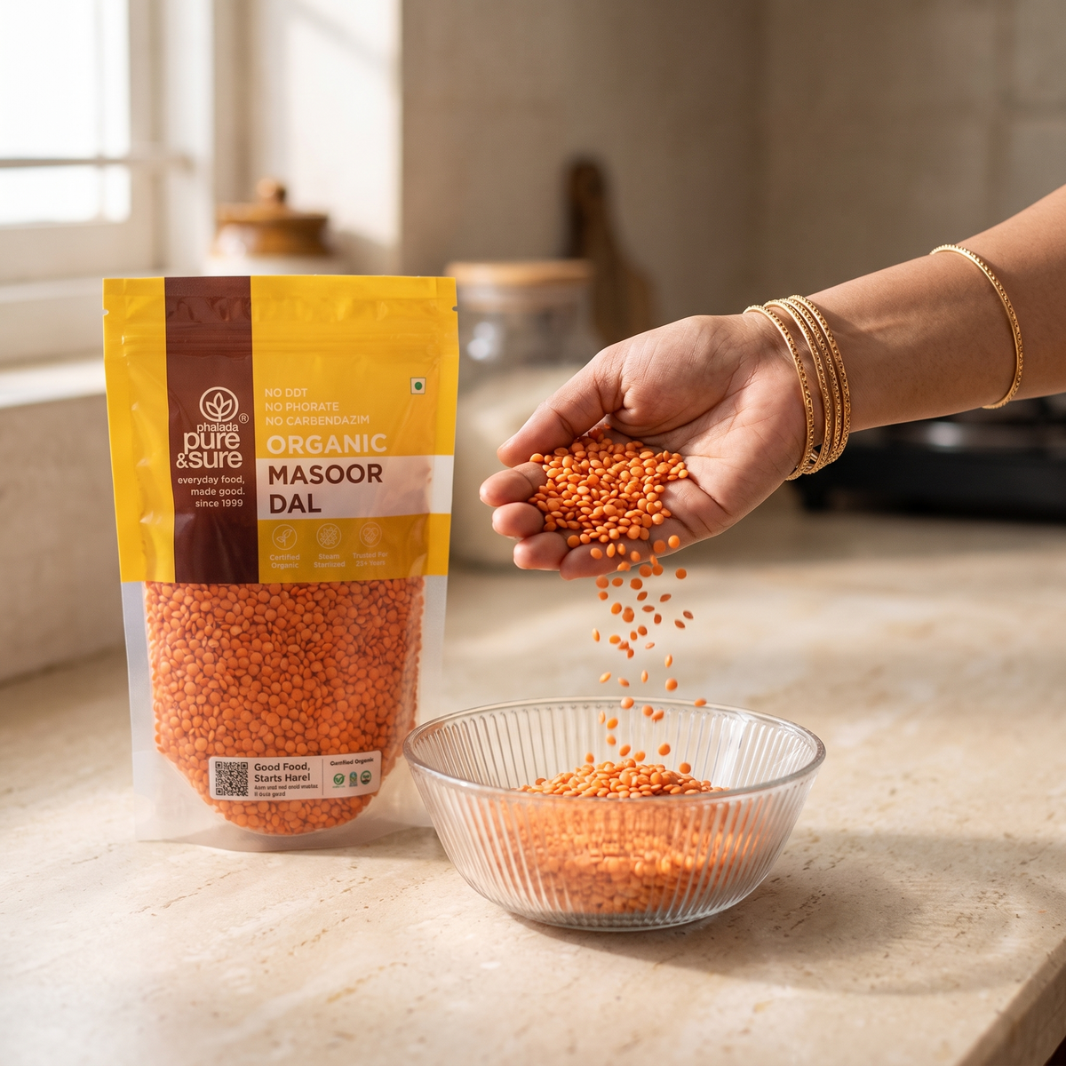Pouring masoor dal into a glass bowl