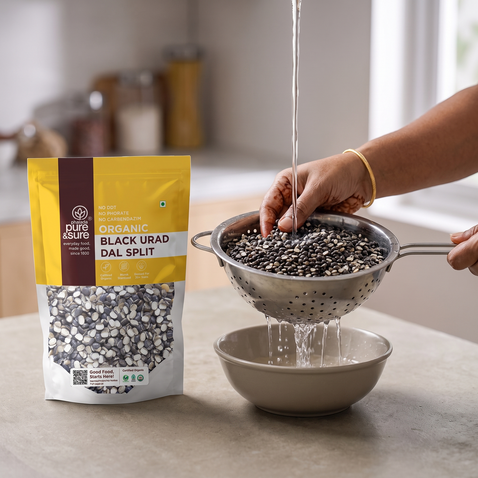 Rinsing black urad split in a colander