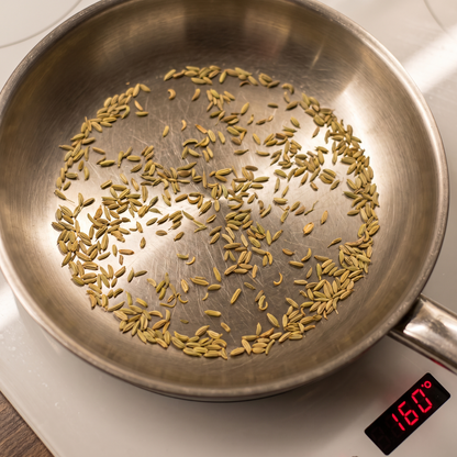 Fennel seeds dry-roasting in a steel pan