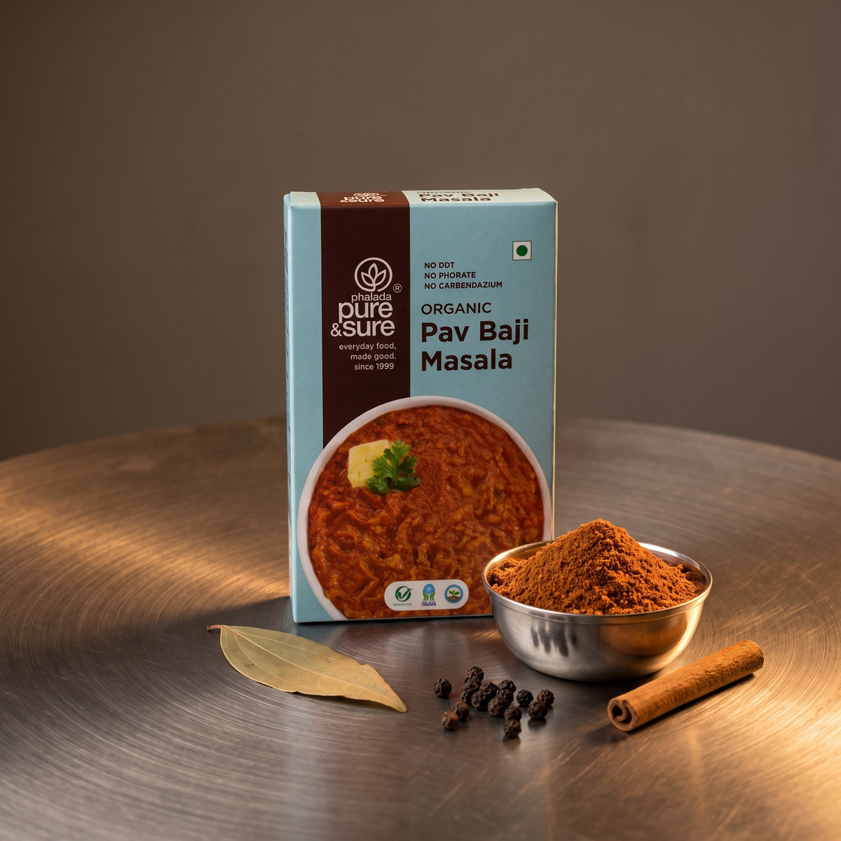Carton with a bowl of pav bhaji masala and whole spices