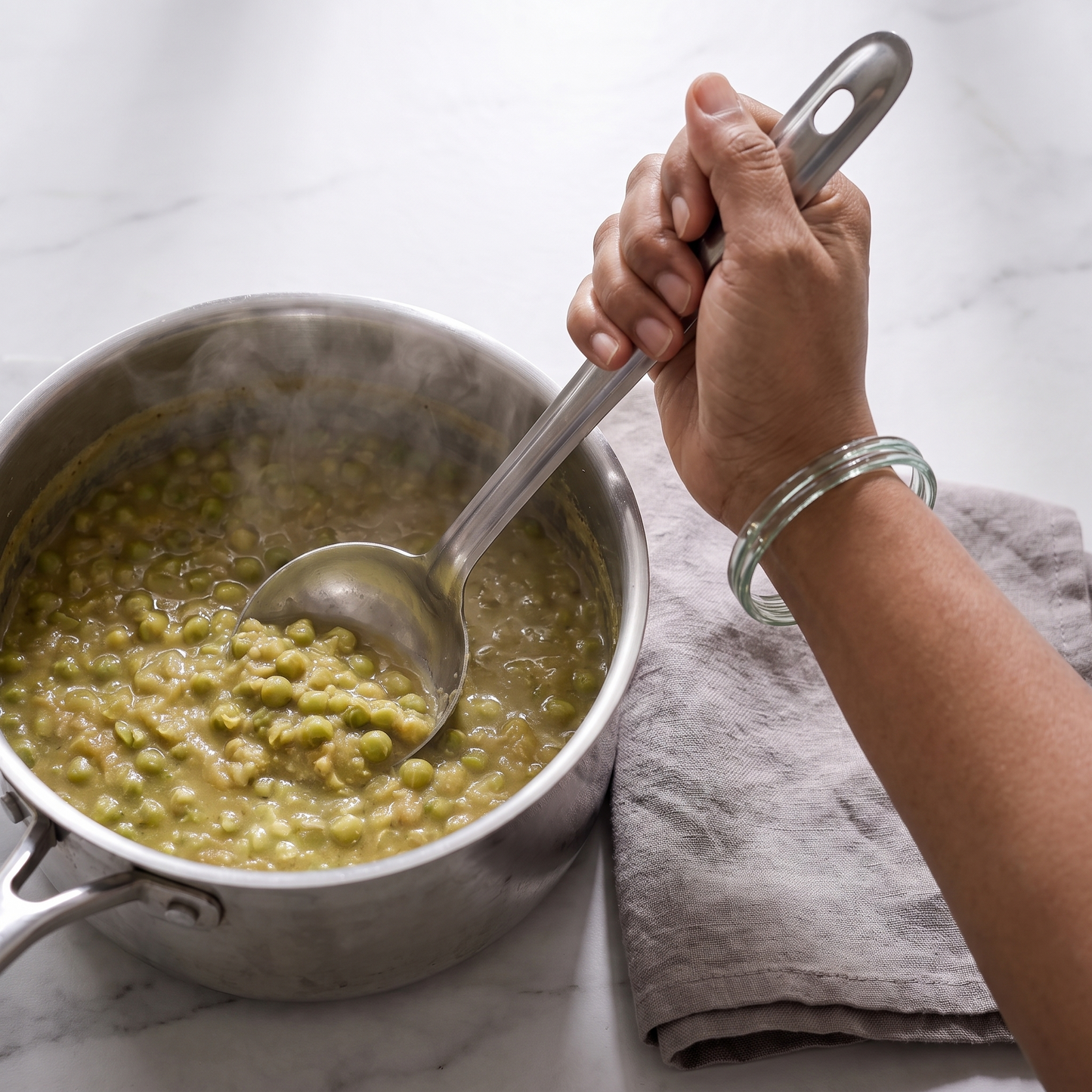 Stirring a pot of cooked dried green peas