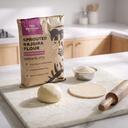 Rajgira dough ball and a rolled roti on a floured counter with the sprouted rajgira atta pack