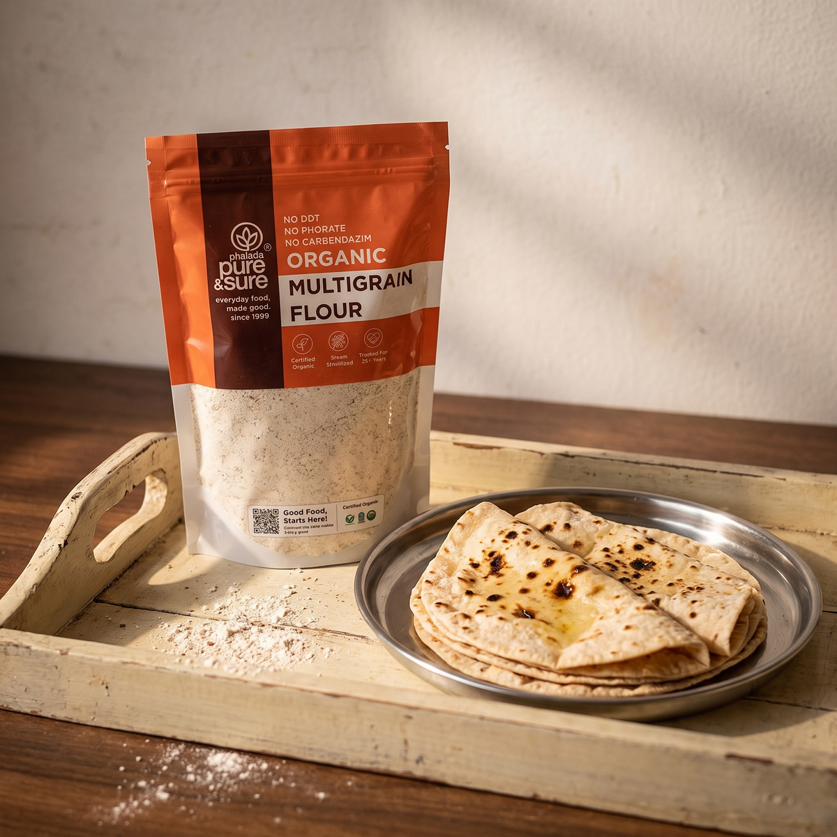 Multigrain flour pack on a wooden tray with soft rotis on a steel plate