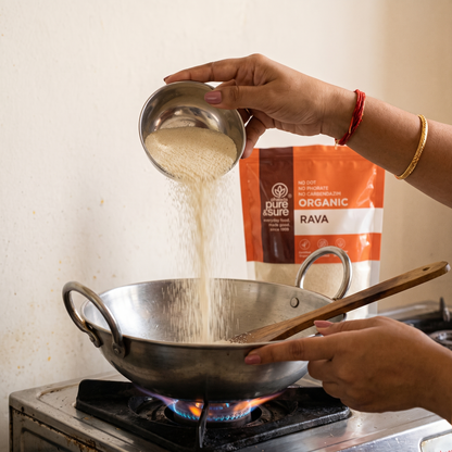 Pouring rava into a hot kadai from a steel bowl, with the pack behind