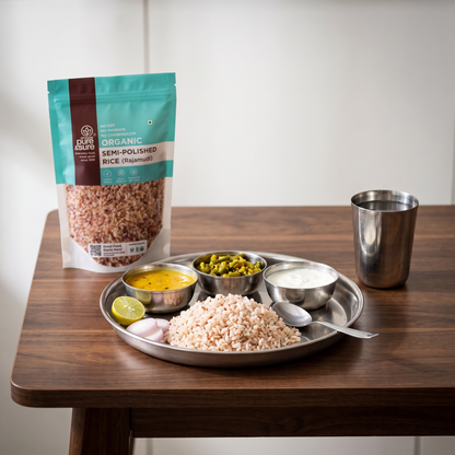 An everyday home lunch of semi-polished Rajmudi rice served on a steel thali with dal, sabzi and curd, the pack behind