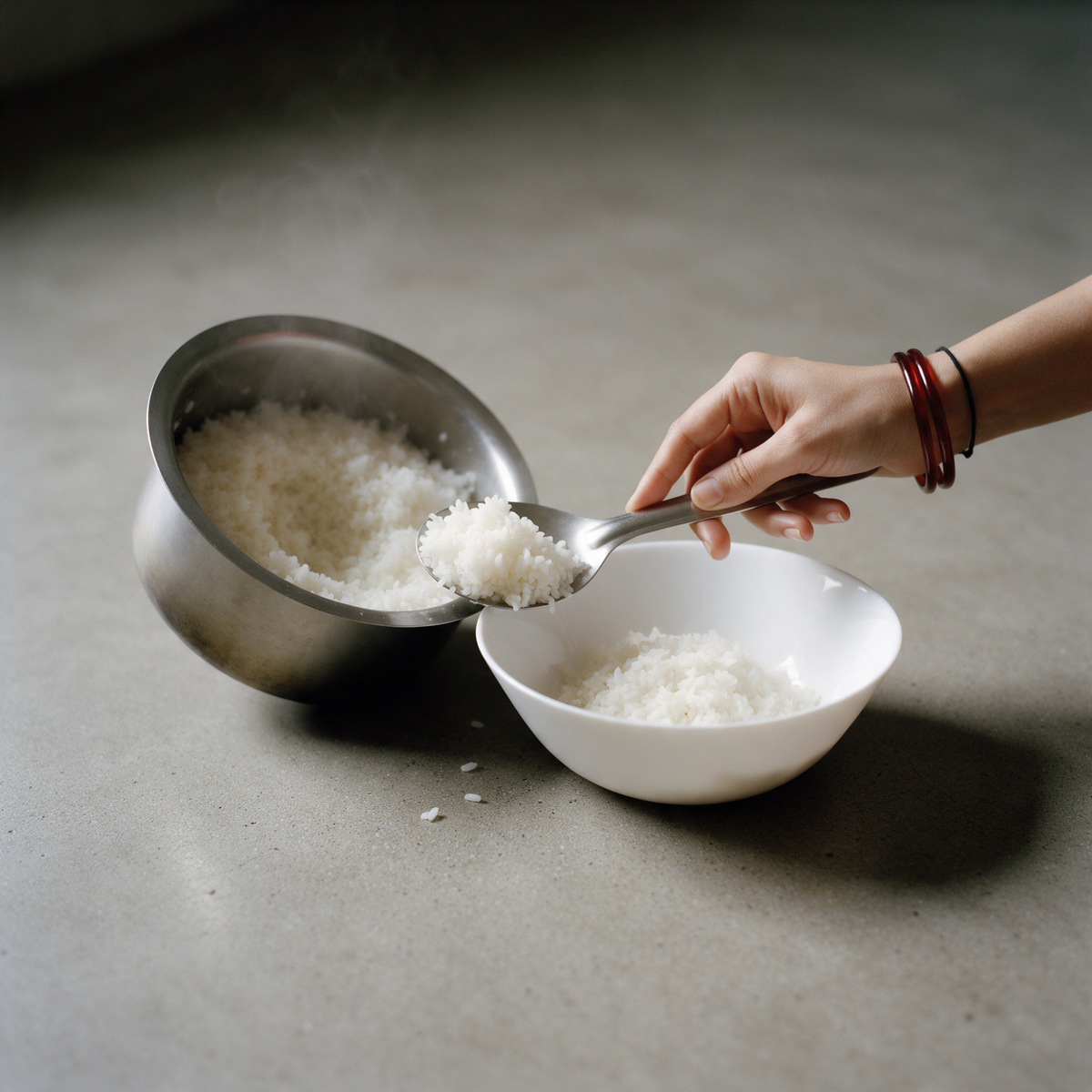 Serving cooked rice from the pot into a bowl