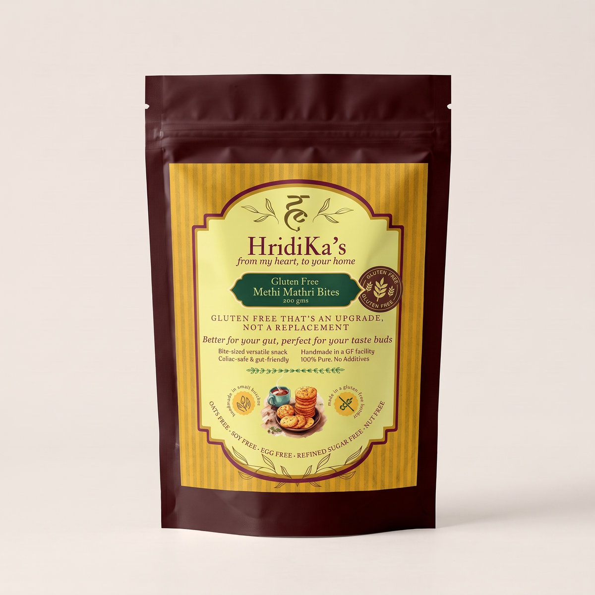 Front of the HridiKa's Gluten Free Methi Mathri Bites 200 g pack, a maroon stand-up pouch with a gold label, standing on a plain white background