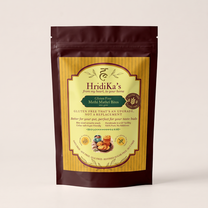 Front of the HridiKa's Gluten Free Methi Mathri Bites 200 g pack, a maroon stand-up pouch with a gold label, standing on a plain white background