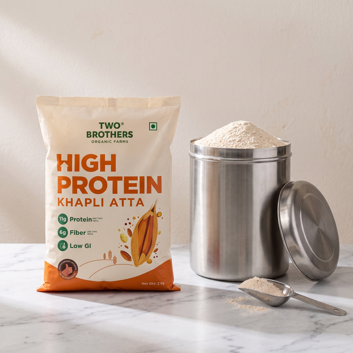 purepicked High Protein Khapli Atta flour bag next to a stainless steel storage canister and a scoop of flour.