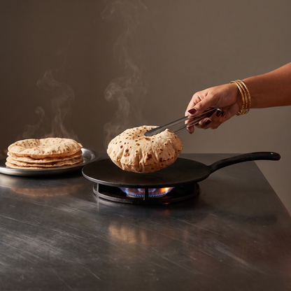 purepicked High Protein Khapli Atta roti being cooked on a hot skillet with a stack of fresh rotis on the side