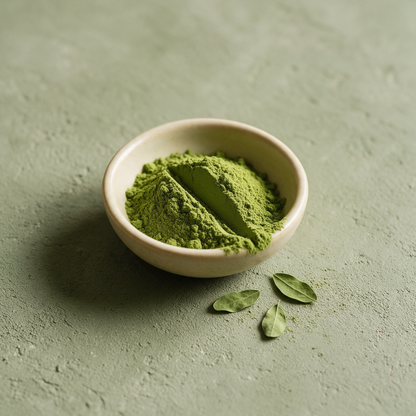 purepicked Moringa Powder in a small ceramic bowl with fresh green leaves on a textured sage green background
